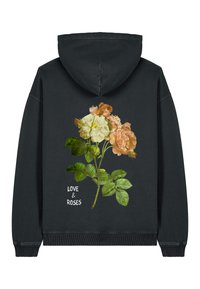 Fekete kapucnis felső narancs és fehér rózsák, valamint zöld levelek virágmintájával, és a "SZERELEM ÉS RÓZSA" felirattal fehér színben.