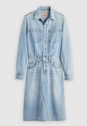 Robe en denim bleu clair avec un devant à boutons, deux poches poitrine, des manches longues et une taille cintrée menant à une jupe évasée.
