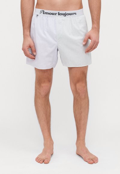 Boxer da uomo a righe blu chiaro e bianche. Tessuto morbido con cintura elastica che riporta la scritta "Amour Toujours." Design comodamente aderente.