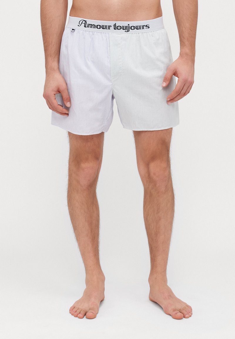 Men's boxers in light blue and white stripes. Soft fabric with an elastic waistband featuring the text "Amour Toujours." Comfortably fitted design.