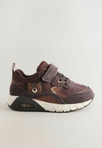 Lilla og brun sneaker med mesh-overdel, ruskindsdetaljer, polstret krave og velcro-lukning. Har en bjørneformet detalje på siden.