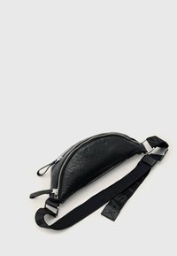 Zwarte leren schoudertas met een afgeronde vorm, gestructureerd oppervlak, zilveren rits en verstelbare band met opvallende zwarte letters.