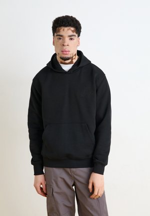 Sweatshirt negru cu glugă, realizat dintr-un material moale, având o buzunar frontal tip kangaroo și un logo discret pe partea stângă a pieptului. Purtați cu pantaloni cargo gri.