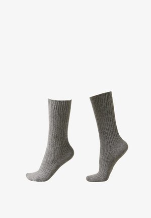 Grå ribbede sokker lavet af blødt materiale, med et mellemlangt design og en forstærket tå for holdbarhed. Ingen mønstre eller accenter.