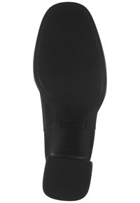 Suela de zapato negra con una superficie lisa y texturizada, forma redondeada y minimalismo en su marca. Cuenta con un tacón bajo y sólido para mayor estabilidad.