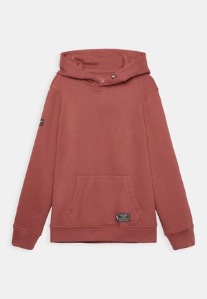 Hoodie de couleur rouille avec poche kangourou à l'avant, manches longues et petites étiquettes de marque noires sur la poche et le bras gauche.