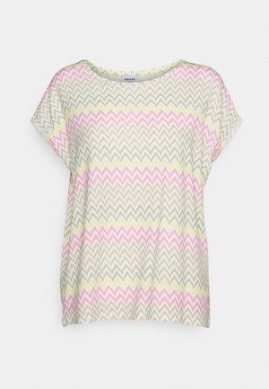 Blouse met korte mouwen en een ronde hals met een zigzagpatroon in roze, geel en lichtgrijs op een crèmekleurige achtergrond.