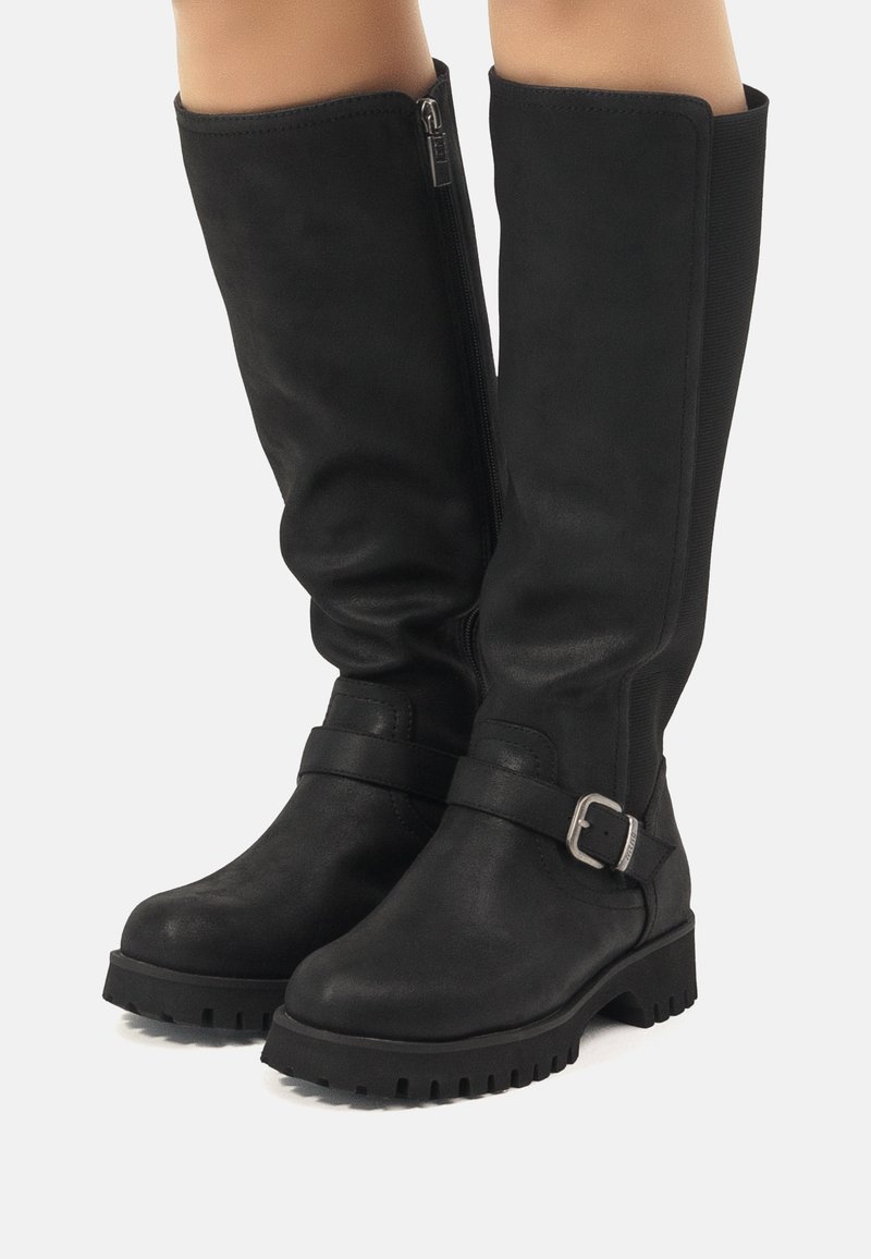 Botas de cuero negras hasta la rodilla con cremallera lateral, un acento de hebilla y una suela rugosa, que exhiben una textura suave y un diseño estructurado.