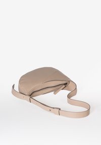 Beige leren schoudertas met een afgeronde vorm, ritsluiting en verstelbare schouderband. Gladde textuur met subtiele stiksels.