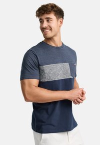 Camiseta de manga corta de color azul marino con una franja horizontal gris y un bolsillo en el pecho. Material de algodón con un ajuste relajado.