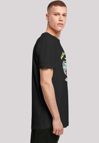 Fekete pamut póló, színes grafikával, amin egy pohár és a "RICK ÉS MORTY" felirat található. Kerek nyakú, rövid ujjú, laza szabású.