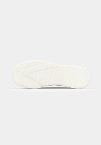 White sneaker sole with textured grip patterns, featuring a smooth rounded shape. No visible branding or decorative elements.
