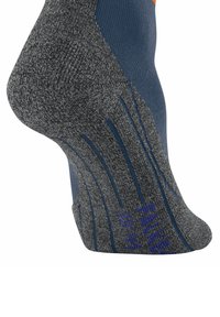 Primo piano di una calza sportiva grigia con accenti e dettagli blu, che mette in risalto il suo materiale flessibile e i dettagli di design sottili.