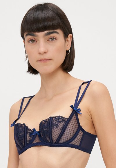 Lietussargu zila krāsa biksītes ar mežģīņu un sietu paneļiem, ar stiepļu balstu, regulējamām siksnām un dekoratīvām lentēm priekšpusē.