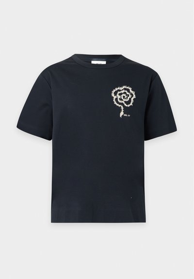 T-shirt noir à manches courtes avec un motif de fleur en spirale blanche et un petit texte "NN_07" sur le côté gauche de la poitrine.