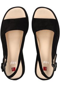 Sandales en daim noir avec une semelle intérieure beige lisse, design à bout ouvert, bride de cheville réglable, et un petit accent carré rouge au niveau du talon.