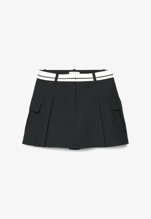 Schwarzer plissierter Minirock mit weißem Taillengürtel und seitlichen Cargotaschen, flach auf weißem Hintergrund ausgelegt.
