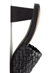 Chaussure en cuir noir avec une texture tissée, design à bout ouvert et talon étroit. Présente un soutien arrière noir uni et une doublure intérieure lisse.