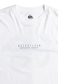 Biela tričko s krátkym rukávom vyrobené z bavlny, s čiernym logom "Quiksilver Boardshort Company" vytlačeným na prednej strane.