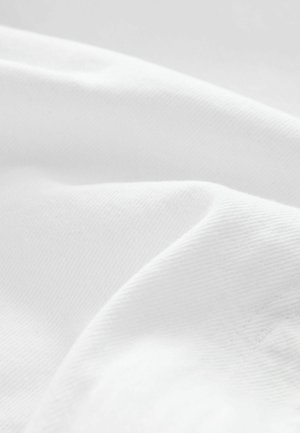 Tela blanca con una textura suave, que presenta un sutil ribete diagonal y un ligero brillo, dispuesta en pliegues suaves y fluidos.