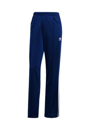 Pantaloni sportivi blu navy realizzati in tessuto liscio, con cintura elastica, tasche laterali e strisce bianche sui fianchi. Logo Adidas.