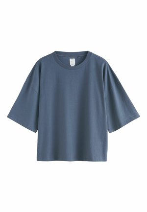 Ljusblå oversized T-shirt i bomull med korta ärmar, rund halsringning och en mjuk textur, med en minimalistisk design.