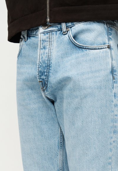 Ανοιχτό μπλε τζιν με ξεθωριασμένο φινίρισμα, που διαθέτει κλασικό σχέδιο με πέντε τσέπες, κλείσιμο με κουμπί και διακριτικές ραφές.