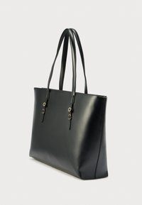 Sac fourre-tout en cuir noir avec deux longues anses, texture lisse, accents de ferrures argentées et forme rectangulaire structurée.