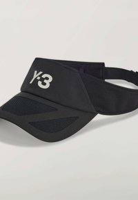 Czarny kapelusz z daszkiem wykonany z lekkiego materiału, z siateczkową wstawką i logo Y-3 w kolorze srebrnym. Regulowany pasek zapewnia pewne dopasowanie.