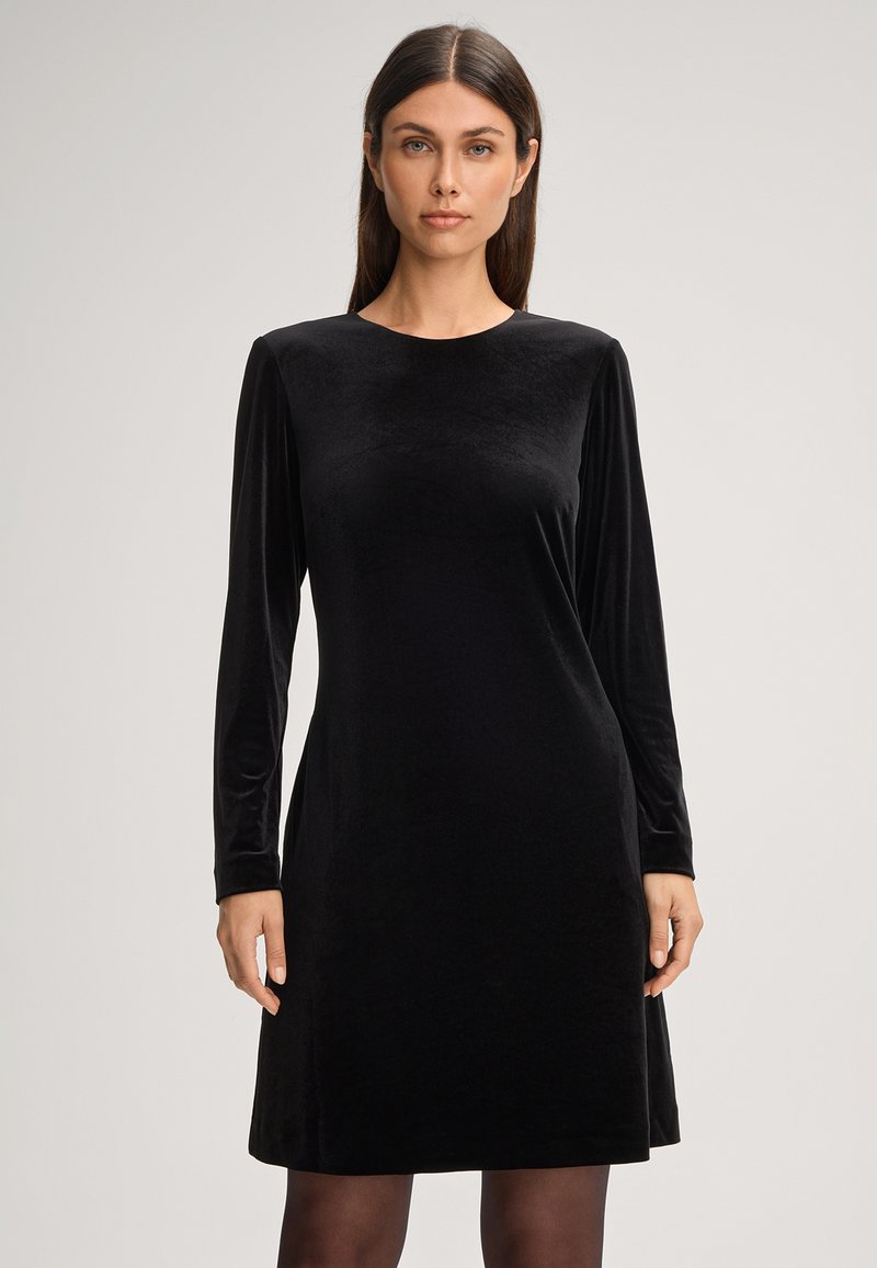 Schwarzes Samtkleid mit langen Ärmeln und Rundhalsausschnitt, weicher Textur und lässigem Schnitt, das bis zur Mitte des Oberschenkels reicht und für verschiedene Anlässe geeignet ist.