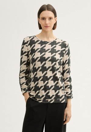 Long-sleeve knit top with a houndstooth pattern in black and cream. Soft texture and relaxed fit, round neckline, and slightly gathered sleeves.