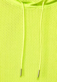 Felpa con cappuccio gialla neon con una texture perforata, dotata di due cordini con estremità in argento. Il materiale è leggero e traspirante.