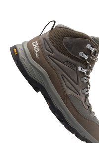 Scarponcino da trekking marrone con design a caviglia alta, sezioni in mesh traspirante e punta rinforzata. Suola Vibram per aderenza; presenta passanti e branding.