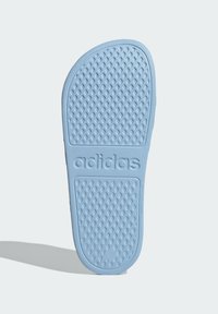Light blue rubber sandal sole with textured surface and diamond patterns. "adidas" logo embossed near the heel area. Flat and oval shape.