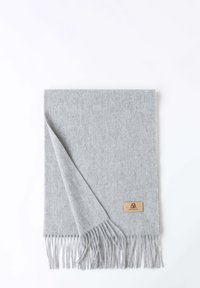Gray wool scarf with fringed edges and a small, rectangular brown leather label. Soft texture, rectangular shape.