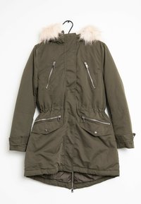 Parka olive avec capuche en fausse fourrure, poches poitrine zippées, poches latérales à rabat et taille à cordon; texture lisse avec un dos plus long.
