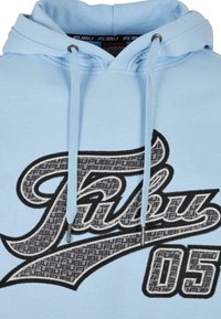 Světlounce modrá mikina s velkým našitým logem „Fubu“ a číslem „05“ v černo-šedém vzoru na hrudi, vybavená šňůrkami s kovovými zakončeními.