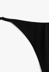 Czarny, trójkątny biustonosz bikini z regulowanymi ramiączkami i g�ładką fakturą, zaprojektowany z myślą o minimalnym zakryciu.