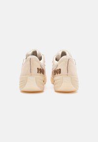 Beige lædersneakers med teksturerede detaljer, der har broderede tal på hælen og en polstret krave for komfort.