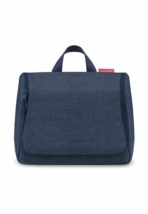 Trousse de toilette de voyage compacte bleu marine avec poignée supérieure, fermeture à double zip, et étiquette de marque "reisenthel" rouge sur fond blanc.