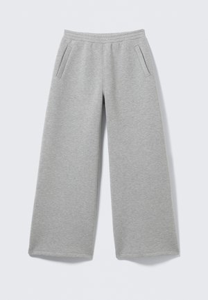 Helle graue, weit geschnittene Sweatpants mit elastischem Bund und seitlichen Eingriffstaschen, flach auf einem weißen Hintergrund ausgelegt.