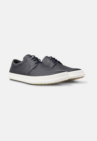 Sneakers in pelle blu navy con punta tonda e chiusura con lacci. Presentano una suola in gomma bianca e una tomaia tessurizzata per un tocco di dettaglio in più.