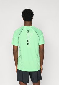 Light green athletic shirt with short sleeves, featuring "climacool" logo and black accents along seams, designed for breathability.