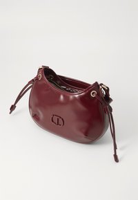 Burgundy leather handbag with a rounded body, gold hardware accents, and adjustable drawstring closure. Smooth texture with logo detail.