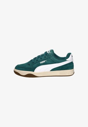 Groene suède Puma-sneaker met witte streep, beige zool en Puma-logo aan de zijkant, op de tong en op de hiel, gezien vanaf de linkerkant.