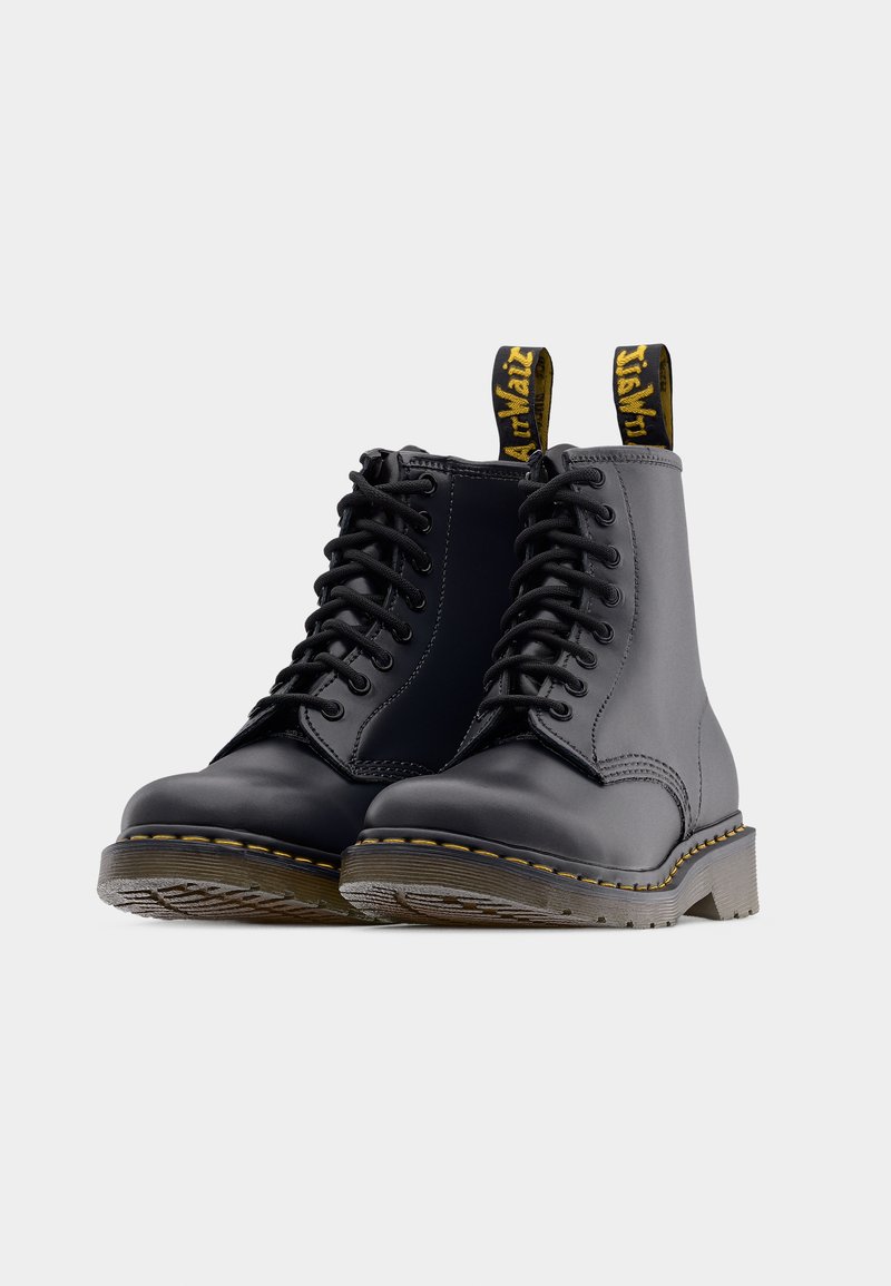 Sorte ankelstøvler i læder med snøredesign, forstærket tå, gule syninger og trækflig med logo. Gummisål med mønster for trækkraft.