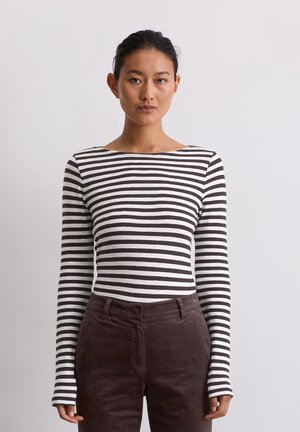 Langsleeve gestreepte top in wit en bruin met een bootnek. Gecombineerd met donkerbruine corduroy broek. De stof ziet er glad en aansluitend uit.