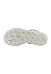 Suela de zapato blanca con múltiples patrones circulares y pequeñas perforaciones. El diseño proporciona tracción con un acabado texturizado.