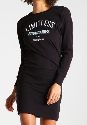 Vestito nero a maniche lunghe con testo grafico "LIMITLESS BOUNDARIES" in bianco e turchese, caratterizzato da una silhouette aderente e tessuto morbido.
