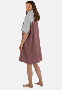 Kapuzentuch-Poncho, halb grau und halb mauve, aus weichem Frottierstoff. Mit kurzen Ärmeln und lockerem Schnitt für optimalen Komfort.